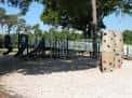 Área de juegos infantiles con toboganes y roca escalable en Henry and Ola Park