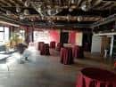 Sala preparada para recepción con mesas redondas cubiertas en rojo