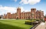 Vista panorámica de la fachada principal de Queen's University Belfast con césped verde
