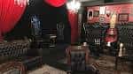 Área de estar con sofás tapizados y cortinas rojas en el SpookEasy Lounge