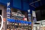 Barra principal del Top Shelf Sports Lounge con iluminación azul