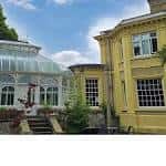 Vista exterior de Carrow House con invernadero adyacente
