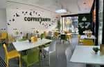 Interior del Coffee Saints con mesas y sillas de colores