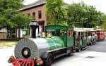 Tren turístico verde recorriendo las calles del parque histórico