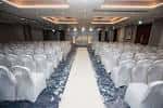 Sala de eventos preparada para una boda con pasillo central y sillas cubiertas