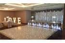 Pista de baile decorada con luces LED y letras luminosas 'LOVE' en el fondo