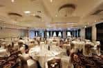 Salón de banquetes con mesas redondas dispuestas para cena formal