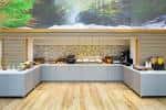 Área de catering o buffet en el interior del hotel con decoración natural y mobiliario contemporáneo
