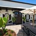 Terraza al aire libre del establecimiento con mesas, sombrillas y decoración vegetal