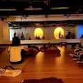 Interior del estudio de yoga con personas practicando y luces circulares