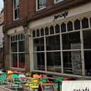 Fachada exterior de Jamcafé con mesas y sillas coloridas en la acera