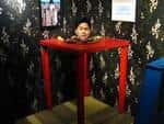 Exhibición interactiva de ilusión visual con mesa roja y fondo decorado