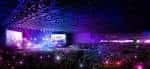 Interior del recinto durante un evento con iluminación escénica y multitud