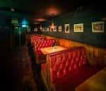 Sala privada del Domino Club con sofás rojos y ambiente íntimo