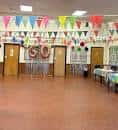 Sala decorada para celebración con banderines y mesa de pastel