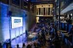 Evento en el interior de Plywood Place con audiencia y pantalla de presentación