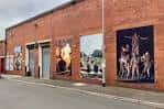Fachada exterior de ladrillo del The Warehouse en Holbeck con murales artísticos