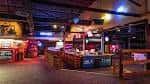 Interior del salón mostrando barra y zona de baile con iluminación ambiental