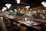 Interior elegante del restaurante con mesas, sofás de cuero y plantas decorativas