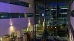 Vista nocturna desde el interior del lobby con grandes ventanales hacia la ciudad