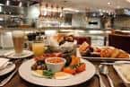 Desayuno buffet servido en restaurante con vista a la cocina abierta