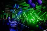 Interior del club con luces verdes y público en la pista de baile