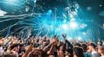 Escena festiva con confeti cayendo sobre una multitud animada bajo luces azules