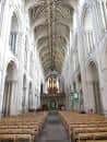 Nave principal de la catedral con bancos de madera y luz natural entrando por las ventanas altas