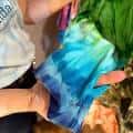 Detalle de una prenda con técnica tie-dye en tonos azules y verdes