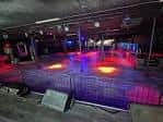 Interior del club con pista de baile iluminada y luces de colores