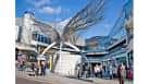 Fachada diurna del Angel Central Shopping Centre con la icónica escultura de alas