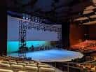 Interior del auditorio con escenario circular y butacas