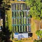 Vista aérea del huerto comunitario con parcelas organizadas y estructuras sostenibles