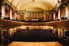 Vista interior del auditorio de Wilton's Music Hall con butacas y escenario