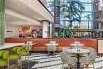 Área lounge interior con diseño contemporáneo y plantas tropicales