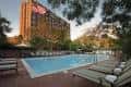 Piscina exterior con tumbonas y vista al hotel Little America