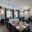 Sala de eventos o comedor del hotel con mesas dispuestas y lámparas de araña