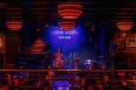 Escenario iluminado con músicos en vivo durante una actuación
