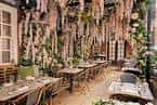 Salón decorado para eventos con colgantes florales y mesas dispuestas para recepción