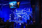 Escenario iluminado en azul con banda tocando en vivo