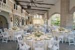 Interior del salón de eventos con mesas redondas y decoración elegante