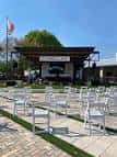Escenario exterior con sillas blancas dispuestas para un evento