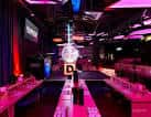 Interior del salón de bingo con iluminación neón y pista central