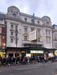Fachada exterior del Apollo Theatre en Leicester Square con público esperando