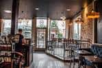 Interior acogedor del café con mesas, sillas y barra de servicio