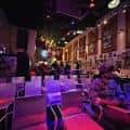 Interior del Red Light Cafe con ambiente de concierto y luces de colores