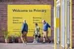 Entrada principal del centro Primary en Nottingham con letrero amarillo y personas caminando