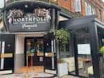 Fachada del North Pole Bar & Grill en Greenwich con letrero iluminado