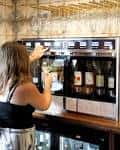 Cliente sirviéndose vino en la máquina de servicio propio del bar
