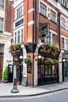 Fachada exterior del pub The White Hart en Covent Garden con decoración de macetas colgantes